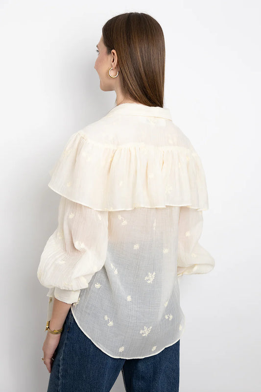 SECULAR Marilou Shirt A soft, cape-like ruffle drapes across the shoulders and back, giving this blouse its romantic, flowing shape. Finished with a feminine neck tie and gently gathered sleeves.