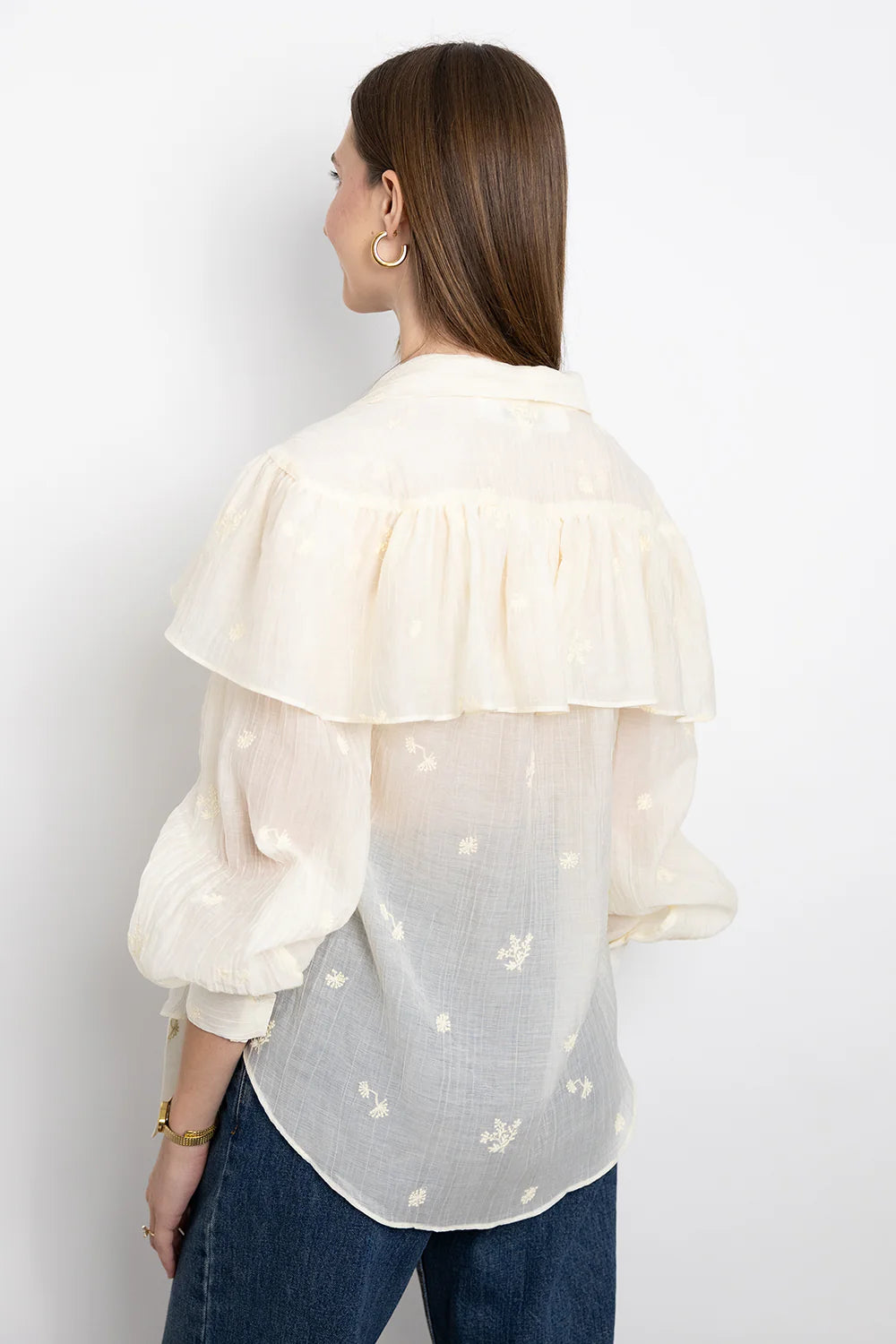 SECULAR Marilou Shirt A soft, cape-like ruffle drapes across the shoulders and back, giving this blouse its romantic, flowing shape. Finished with a feminine neck tie and gently gathered sleeves.