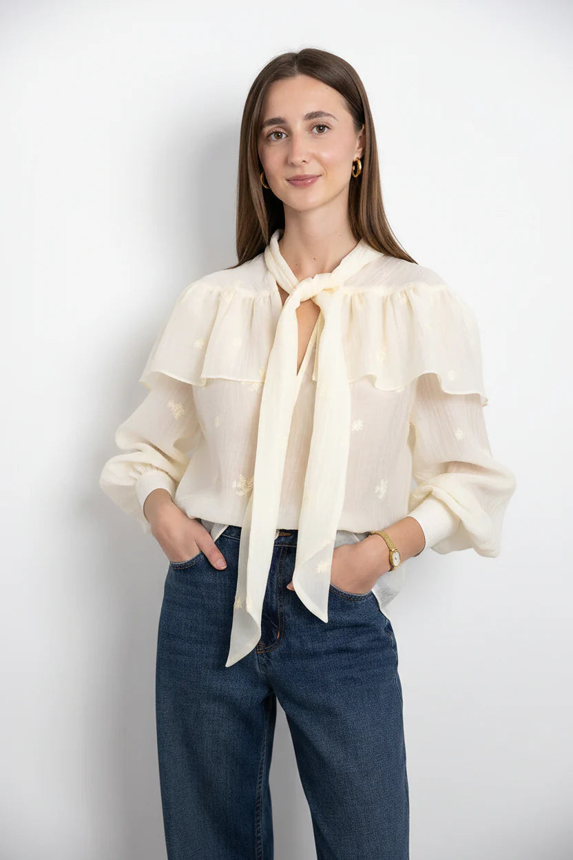 SECULAR Marilou Shirt A soft, cape-like ruffle drapes across the shoulders and back, giving this blouse its romantic, flowing shape. Finished with a feminine neck tie and gently gathered sleeves.