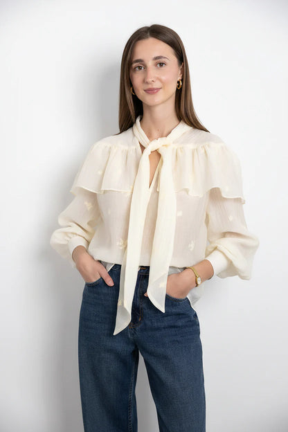 SECULAR Marilou Shirt A soft, cape-like ruffle drapes across the shoulders and back, giving this blouse its romantic, flowing shape. Finished with a feminine neck tie and gently gathered sleeves.