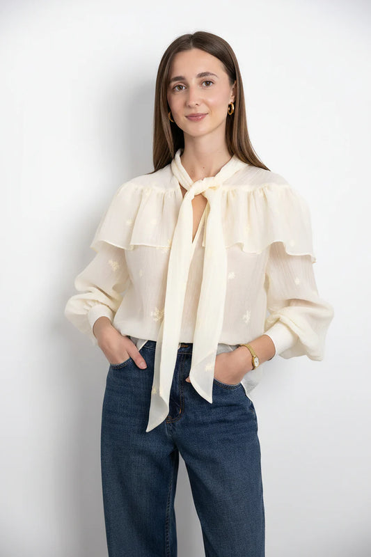 SECULAR Marilou Shirt A soft, cape-like ruffle drapes across the shoulders and back, giving this blouse its romantic, flowing shape. Finished with a feminine neck tie and gently gathered sleeves.