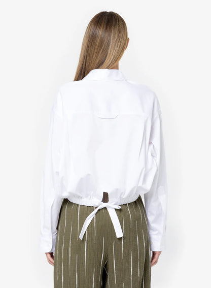 The Emery Top by JBQ in White features a cropped fit, dropped shoulders, chest pocket, and self-tie waistband, women's clothing